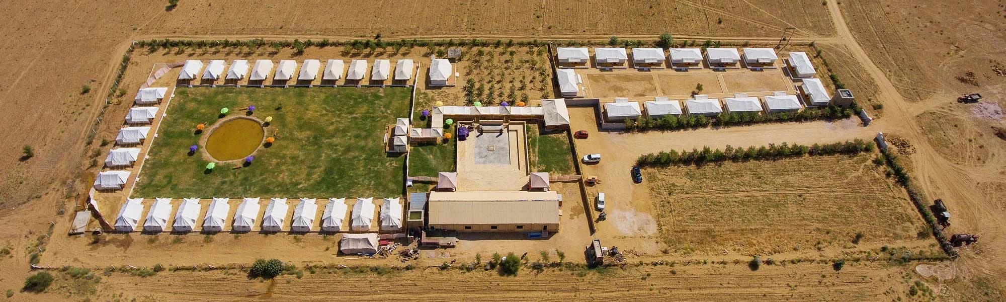 Aerial view of Camp e Khas, its lawns and tents in the open desert