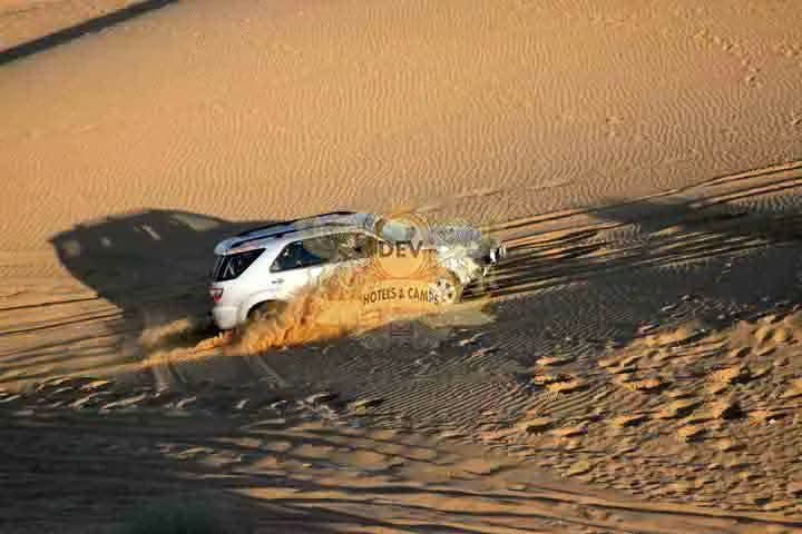 SUV cresting a dune