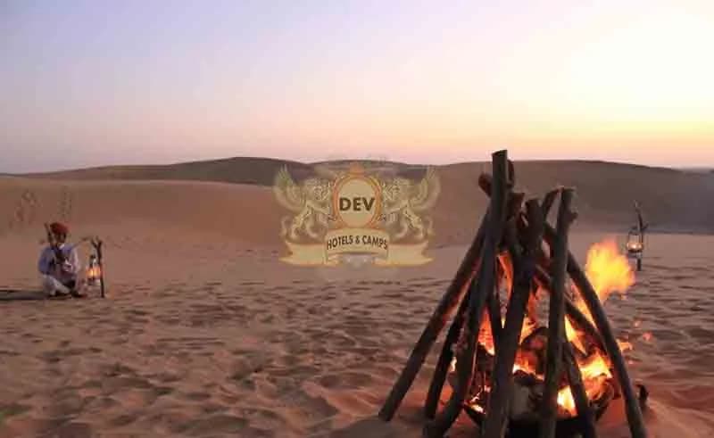 Musicians beside a bonfire on the dunes at dusk